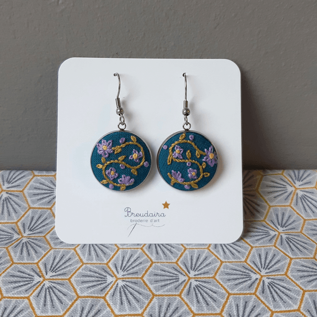 Boucles d&#039;oreilles fleurs mauves fond bleu